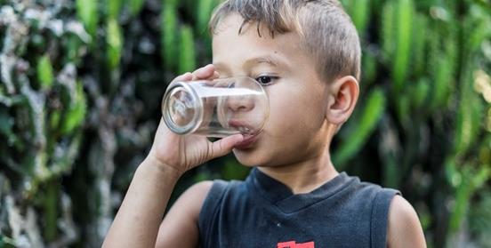 niño bebe agua